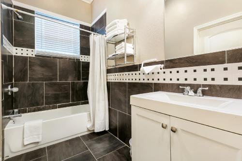 a bathroom with a sink and a tub and a toilet at Inviting 3BR Condo steps from St Charles Ave in New Orleans