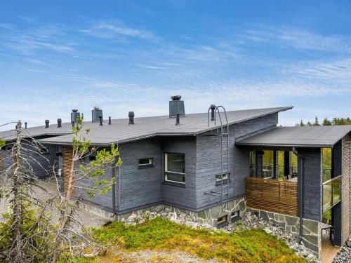 a gray house with a roof on top of it at Holiday Home Rukavuorenhuippu 23 a by Interhome in Ruka