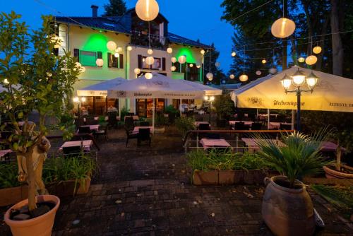 an outdoor restaurant with tables and umbrellas at night at Boutique Hotel Sena in Berlin