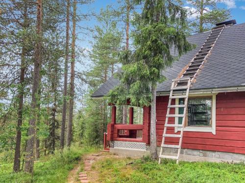 ein rotes Haus mit einer Leiter an der Seite in der Unterkunft Holiday Home Pajalan hirsitupa by Interhome in Kuusamo