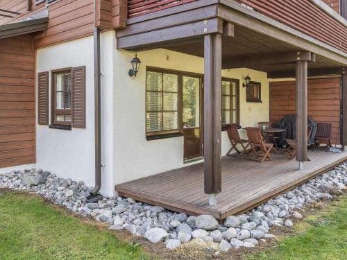 eine Holzterrasse an der Seite eines Hauses in der Unterkunft Holiday Home Alppitalo punatähti 7 apt 2 by Interhome in Tahkovuori