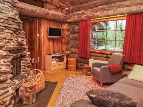 a log cabin living room with a stone fireplace at Holiday Home Luostonseita 3 by Interhome in Luosto