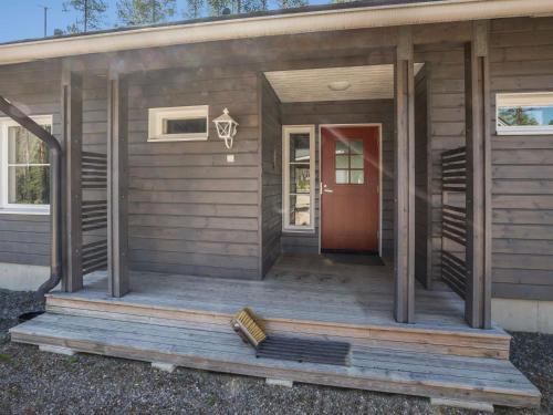ユッラスヤルヴィにあるHoliday Home Ylläs siesta by Interhomeの赤い扉付きの木製のポーチのある家