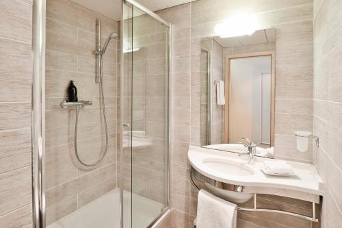 a bathroom with a shower and a sink at Aparthotel Adagio Genève Mont-Blanc in Geneva