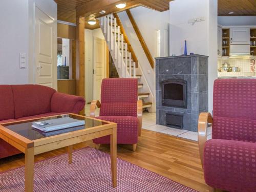 a living room with red chairs and a fireplace at Holiday Home Alppitalo punatähti 7 apt 4 by Interhome in Tahkovuori