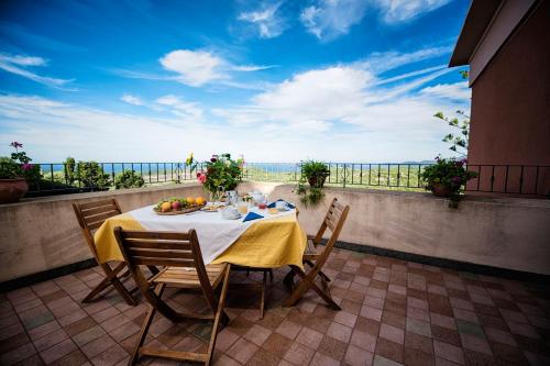 a table on a balcony with a view of the ocean at Hotel Villa Gli Asfodeli in Tresnuraghes