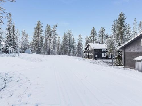 a snow covered road in front of a house at Holiday Home Uuvana by Interhome in Äkäslompolo