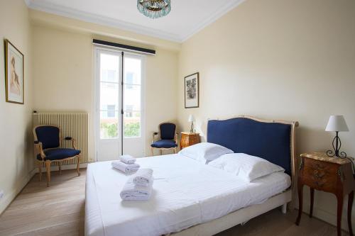 カンヌにあるHavre de paix au coeur de Cannesのベッドルーム1室(ベッド1台、椅子2脚、窓付)
