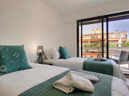 une chambre avec deux lits et une grande fenêtre dans l'établissement Nestor&Jeeves - DIAMOND BAY TERRACE - Central - Close sea, à Nice
