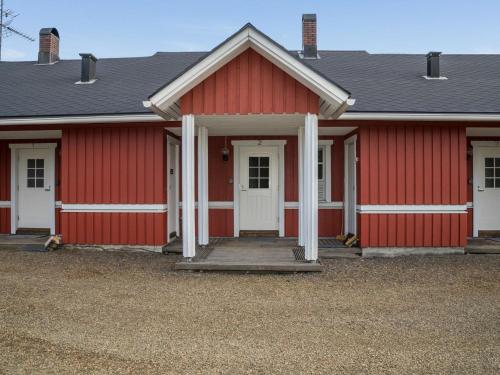 Une grange rouge avec une porte blanche et une véranda dans l'établissement Holiday Home Ylläskarpalo 2 keskimmäinen by Interhome, à Äkäslompolo