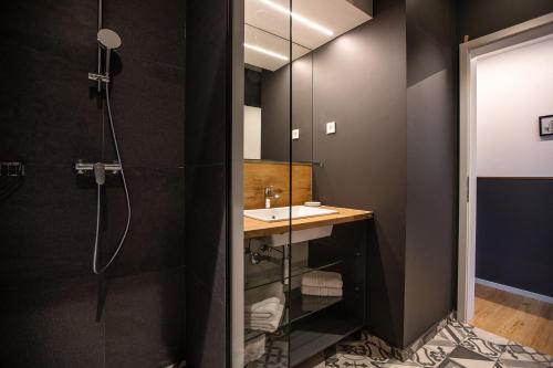 a bathroom with a sink and a shower at Postcard City Apartments in Maribor