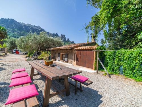 a picnic table and chairs in front of a house at Holiday Home Cala Tuent by Interhome in Cala Tuent