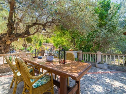 una mesa de madera y sillas en un patio en Holiday Home Cala Tuent by Interhome, en Cala Tuent