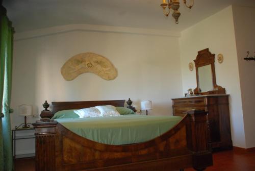 a bedroom with a wooden bed and a mirror at Agriturismo Le Volte in Mocaiana
