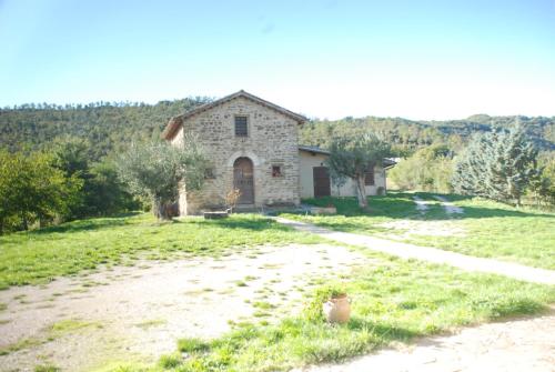 a stone house in a field next to a dirt road at Agriturismo Le Volte in Mocaiana