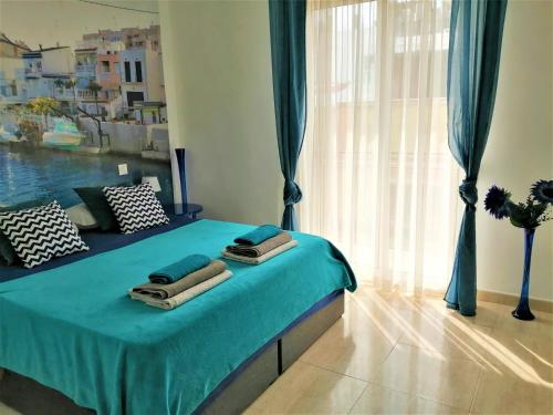 a bedroom with a bed with blue sheets and a window at Unigue Design Apartment, Gandia in Gandía
