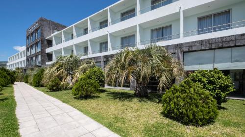 a large building with a large lawn outside of it at Hotel Vale Do Navio in Capelas