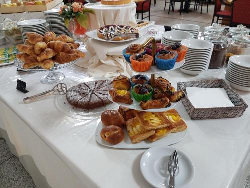 a table topped with plates of pastries and desserts at RHI Porta Bologna in Pieve di Cento