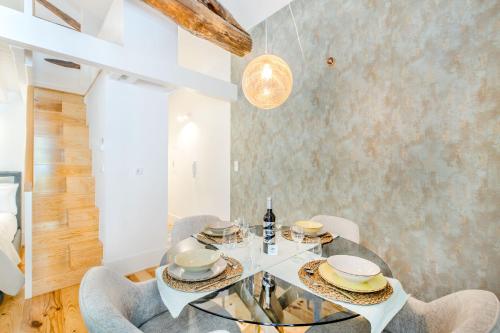 uma sala de jantar com uma mesa de vidro e cadeiras em Santa Catarina Charming Loft no Porto
