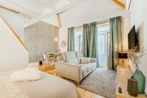 uma sala de estar com um sofá branco e uma televisão em Santa Catarina Charming Loft no Porto