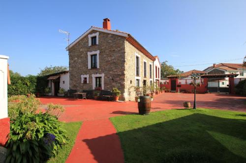 una casa con un patio de ladrillo con césped en El Perlindango, en Villademar