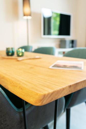 a wooden table in an office with green chairs at AKZENT Apartmenthotel Binz in Binz