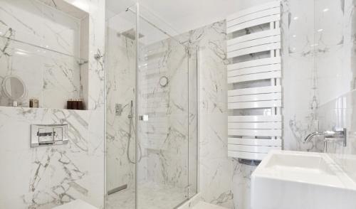 La salle de bains blanche est pourvue d'une douche et d'un lavabo. dans l'établissement Apartament Sea Towers View, à Gdynia