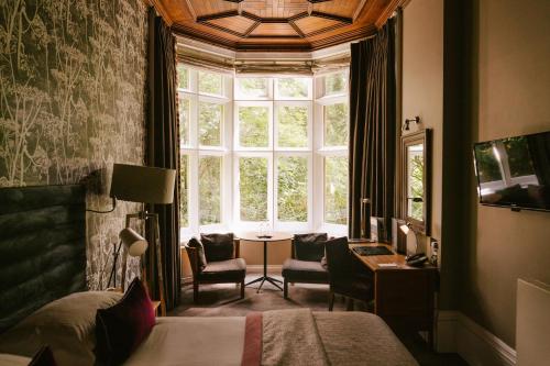 a bedroom with a bed and a window and a table at Jesmond Dene House in Newcastle upon Tyne