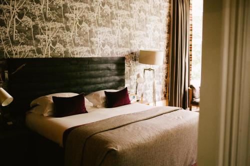a bedroom with a large bed with a black headboard at Jesmond Dene House in Newcastle upon Tyne