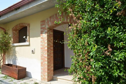 a door to a house with a cat sitting in a window at Agriturismo Tenuta Lagala in Venosa