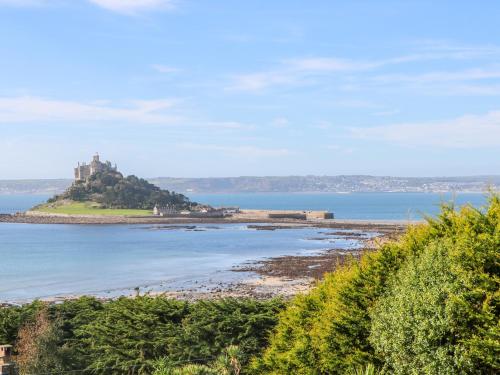 an island in the water with a castle on it at The Stables in Penzance