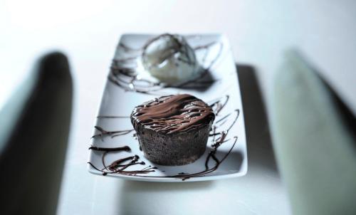 a chocolate cupcake on a plate on a table at Marelia Hotel in Poligiros