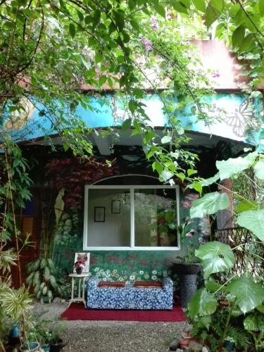 a window in the side of a house with plants at Toni Arts Villa in Nabas