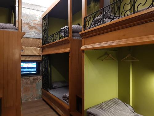 a room with two bunk beds with green walls at Tepbunthom Hostel in Bangkok