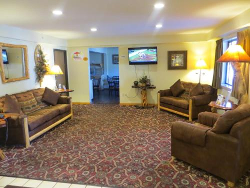 a living room with couches and a flat screen tv at Super 8 by Wyndham Bridgeview of Mackinaw City in Mackinaw City