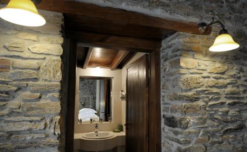 a stone bathroom with a sink and a mirror at Marelia hotel in Poligiros