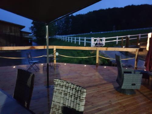 a patio with chairs and an umbrella at night at Ferienwohnungen & Landlust Fulda in Petersberg