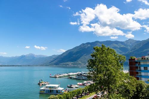 a view of a lake with boats docked at H4 Hotel Arcadia Locarno in Locarno