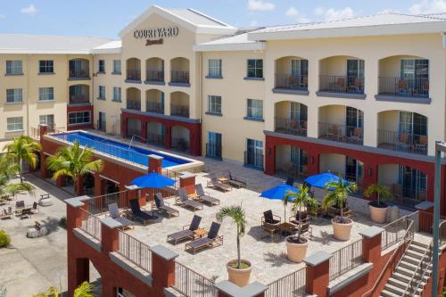 
a large building with a patio area with tables and chairs at Courtyard by Marriott Bridgetown, Barbados in Bridgetown
