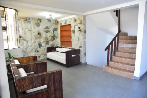 a living room with a couch and a stone wall at Qallwa Asia in Asia