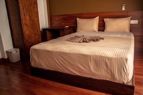a bedroom with a large bed with white sheets at Canal's Edge in Negombo