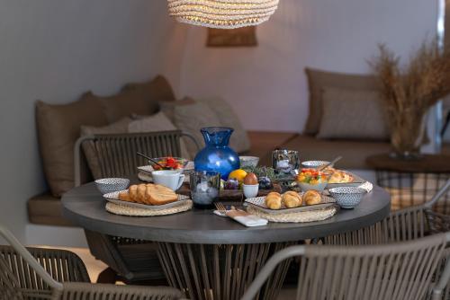 a table with bread and other food on it at White Santorini in Imerovigli