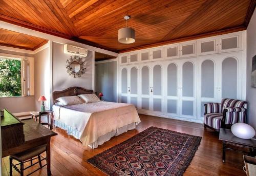 um quarto com uma cama e um tecto de madeira em Villa Alexandrino no Rio de Janeiro