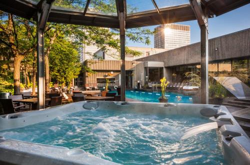 a jacuzzi tub in a patio with a pool at Hotel Bonaventure Montreal in Montreal