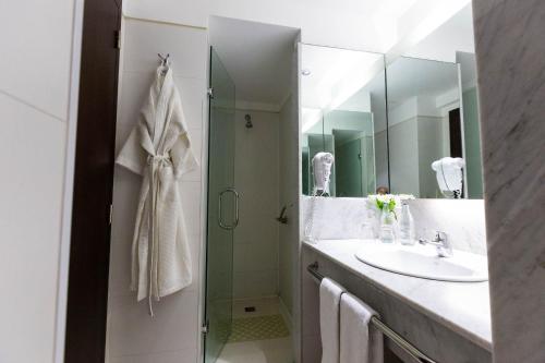a bathroom with a sink, mirror, and towel rack at 474 Buenos Aires Hotel in Buenos Aires
