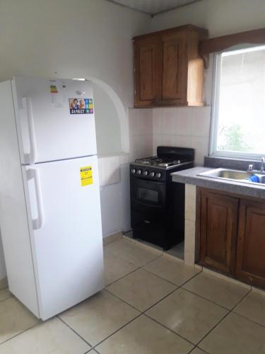 a kitchen with a white refrigerator and a stove at CASA MARLE in Boquete
