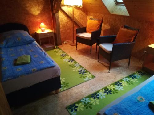 - une chambre avec un lit, deux chaises et une table dans l'établissement Private Světluška, à Poběžovice