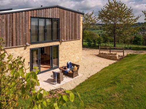 a person sitting in a chair in front of a house at Vineyard Barn Room in Woodchester