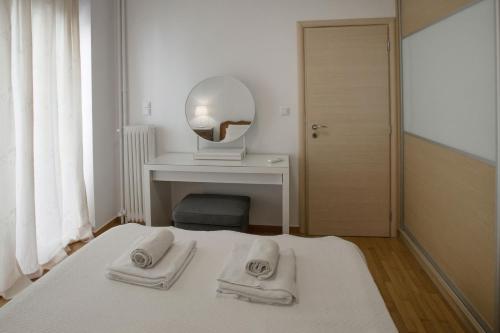 Un dormitorio blanco con una cama con toallas. en Edem BeachFront SeaView Dream Home In Beautiful Athens Riviera in Palaio Faliro, en Atenas