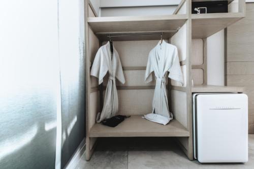 a walk in closet with white clothes and a refrigerator at RYO KAN Ciudad de México in Mexico City